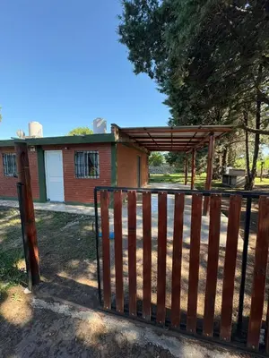 a wooden gate with a wooden canopy in front of a house at Las tres lunas in Villa Anizacate