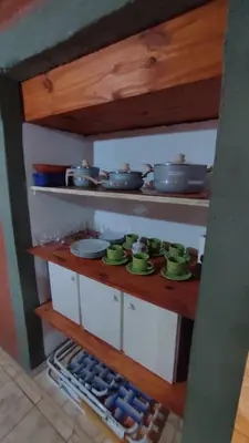 a kitchen with green mugs and pots and pans at Las tres lunas in Villa Anizacate