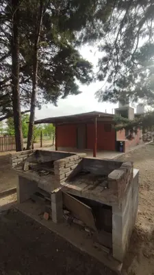 a wooden bench sitting in front of a building at Las tres lunas in Villa Anizacate