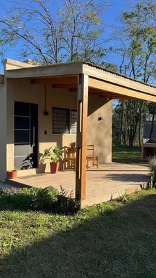 a covered porch of a house with a bench at Cabaña tranquila y gran parque ideal para parejas in Villa Anizacate