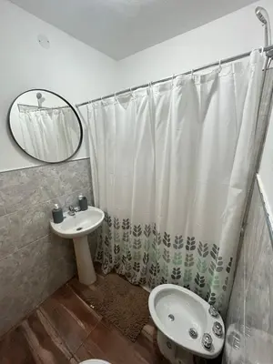 a bathroom with a shower curtain and a sink at Cabaña tranquila y gran parque ideal para parejas in Villa Anizacate