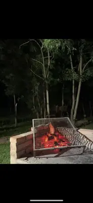 a fire pit in a park with red peppers at Cabaña tranquila y gran parque ideal para parejas in Villa Anizacate