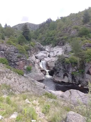 a stream of water flowing down a rocky hill at Adlerhaus in La Cumbrecita