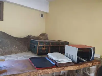 a room with a table with a microwave and luggage at Adlerhaus in La Cumbrecita