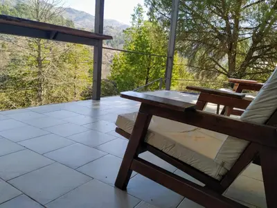 a porch with a bench and a view of the mountains at Adlerhaus in La Cumbrecita