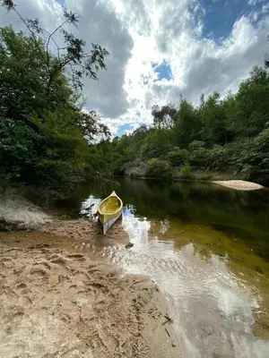 a yellow boat sitting on the shore of a river at Adlerhaus in La Cumbrecita