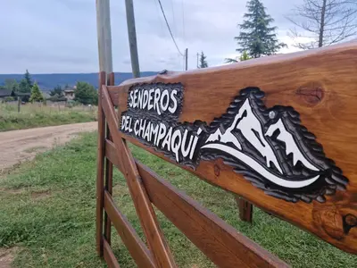 a wooden bench with a sign on it at Cabaña Senderos del Champaquí in Villa Yacanto