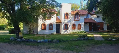 a white house with a tree in front of it at Tinkunaco Merlo in Merlo