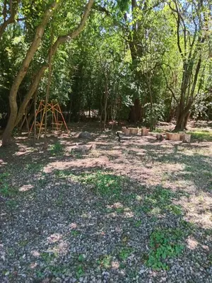 a park with a playground in the middle of trees at Tinkunaco Merlo in Merlo