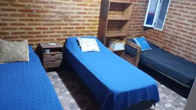 a room with two beds and a brick wall at Cabaña 1 in Arroyo de Los Patos