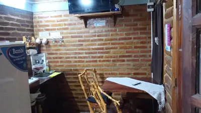 a room with a brick wall with a table and a chair at Cabaña 1 in Arroyo de Los Patos