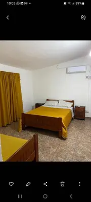 a bedroom with a large bed with a yellow blanket at Elrincondemaximo in Santa Rosa de Calamuchita