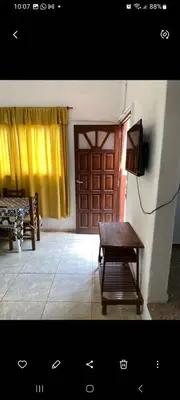 a room with a door and a bench and a television at Elrincondemaximo in Santa Rosa de Calamuchita