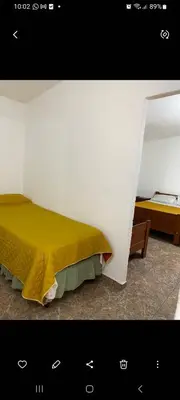 a bedroom with a bed with a yellow bedspread at Elrincondemaximo in Santa Rosa de Calamuchita