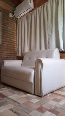 a white couch sitting in a room with a window at Aimara Casas de alquiler in Mina Clavero