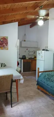 a kitchen with a table and a refrigerator in a room at Sol y Luna in Barrio Parque El Corcovado