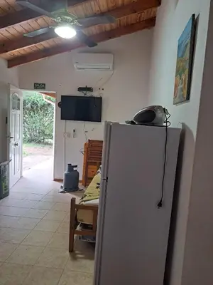 a kitchen with a refrigerator and a table and a tv at Sol y Luna in Barrio Parque El Corcovado