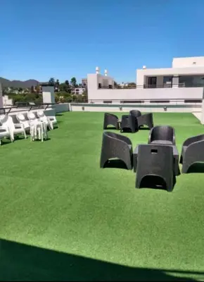a group of chairs sitting on a field of grass at Departamento centro Carlos Paz in Villa Carlos Paz
