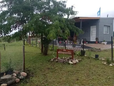 a sign in front of a house with a yard at Elmosquetal in Villa Yacanto