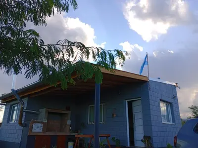 a blue house with a flag on top of it at Elmosquetal in Villa Yacanto