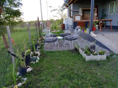a garden with chairs and plants in a yard at Elmosquetal in Villa Yacanto