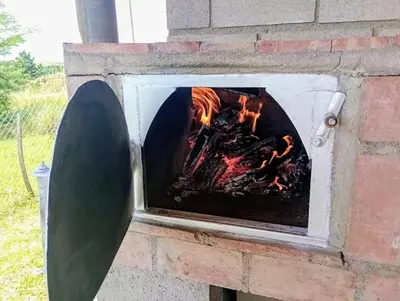a brick oven with a fire in it at Elmosquetal in Villa Yacanto
