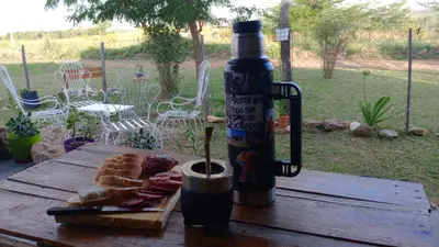 a table with a bottle of sauce and a plate of food at Elmosquetal in Villa Yacanto