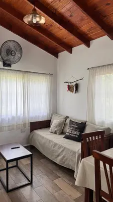 a living room with a bed and a table at Cabañas Los Molles in Arroyo de Los Patos