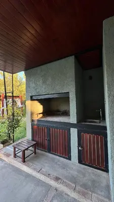 a outdoor kitchen with a bench and a table at Cabañas Los Molles in Arroyo de Los Patos