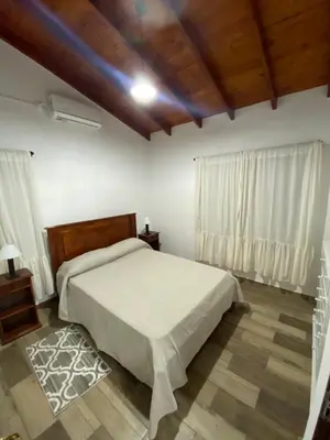 a bedroom with a bed and a wooden ceiling at Cabañas Los Molles in Arroyo de Los Patos