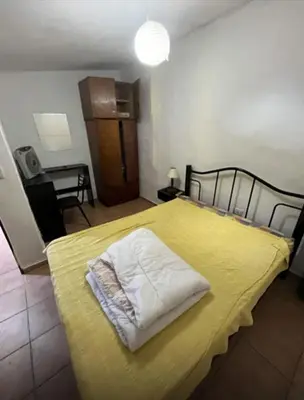 a bedroom with a bed with a yellow bedspread at Casa interna en Playas de Oro Carlos Paz in Villa Carlos Paz