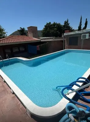a large swimming pool with blue water in a building at Casa interna en Playas de Oro Carlos Paz in Villa Carlos Paz