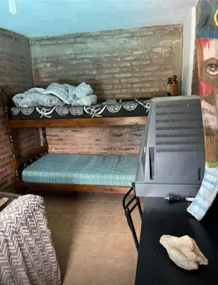 a room with a bunk bed and a table with a laptop at Casa interna en Playas de Oro Carlos Paz in Villa Carlos Paz