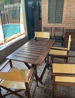 a wooden table and chairs on a patio at Casa interna en Playas de Oro Carlos Paz in Villa Carlos Paz