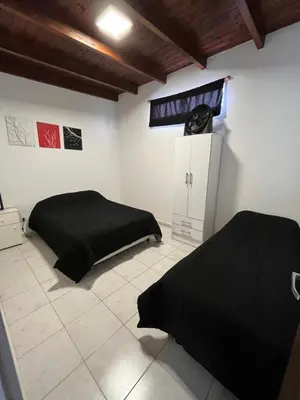 a bedroom with two beds and a clock on the wall at Complejo Joaquina in Río Cuarto