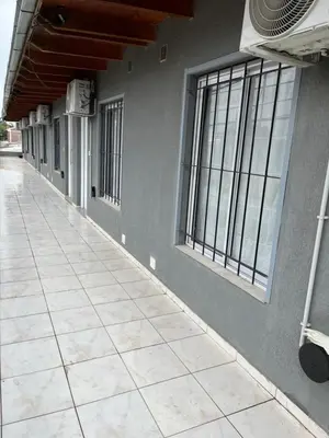 an empty hallway of a building with windows at Complejo Joaquina in Río Cuarto
