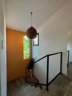 a hallway with stairs and a pendant light at casa junto al rio para 7 in Villa Carlos Paz