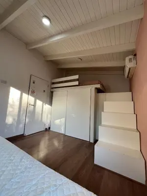 a room with a bed and stairs in it at casa junto al rio para 7 in Villa Carlos Paz