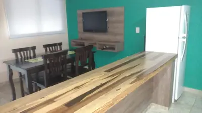 a kitchen with a dining room with a table and a tv at Aires de Montaña cabañas in La Estancia