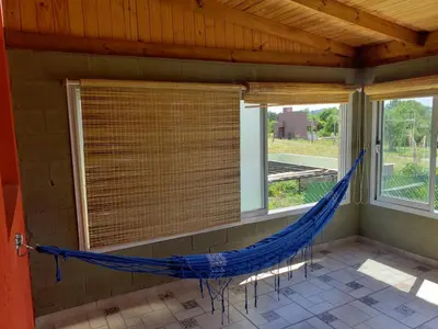a hammock in a room with two windows at Aires de Montaña cabañas in La Estancia