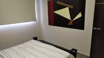 a bedroom with a bed with a painting on the wall at Aires de Montaña cabañas in La Estancia