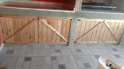 a garage with two wooden doors in a room at Aires de Montaña cabañas in La Estancia