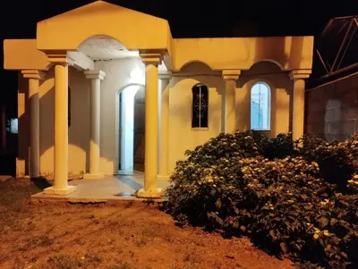 a house with columns and a porch at night at Los duraznos in Villa Cura Brochero