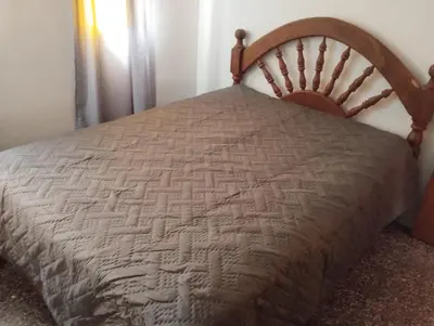 a bed in a bedroom with a wooden headboard at Los duraznos in Villa Cura Brochero