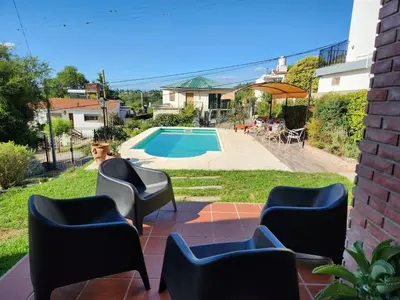 a patio with chairs and a swimming pool at Casa Chalet Carlos Paz in Villa Carlos Paz