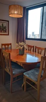 a dining room table with chairs and a large window at Depto 2 Dormitorios en centro de Córdoba, amplio y luminoso in Cordoba