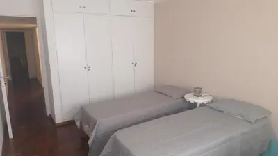a bedroom with two beds and a table and cabinets at Departamento con Estilo centro Cordoba - Cañada y Av Colon in Cordoba