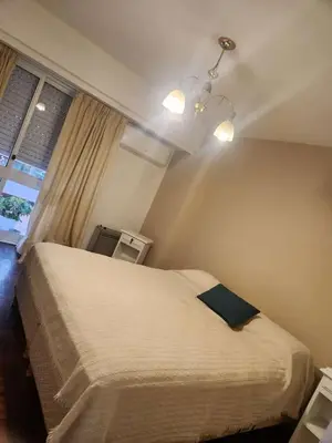 a bedroom with a bed with a blue pillow on it at Departamento con Estilo centro Cordoba - Cañada y Av Colon in Cordoba