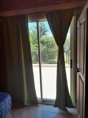 a bedroom with a large glass door with a window at Remanso in La Estancia