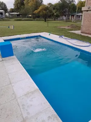 a large swimming pool with blue water in a yard at Remanso in La Estancia